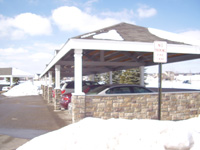 Carport with stone siding and supported pillars